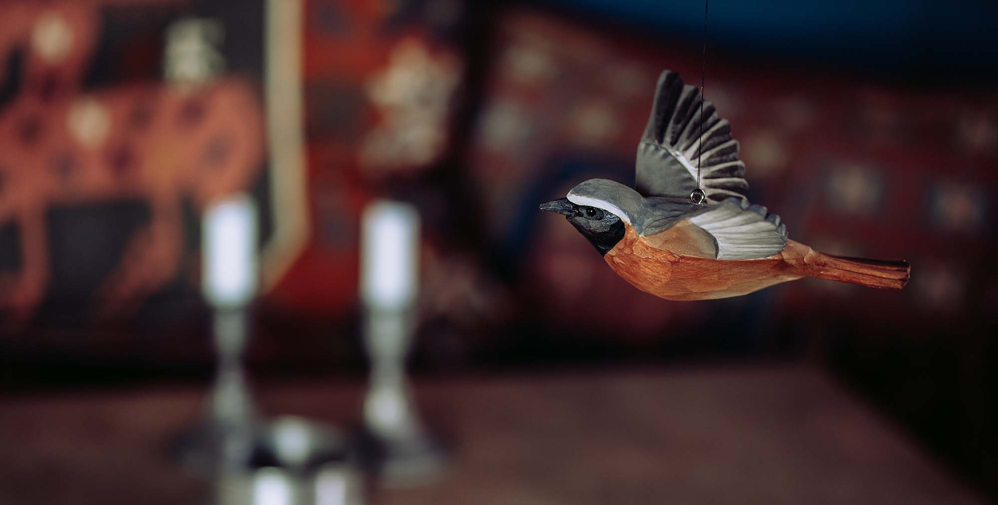 Fliegender Gartenrotschwanz als Holzvogel zur Dekoration